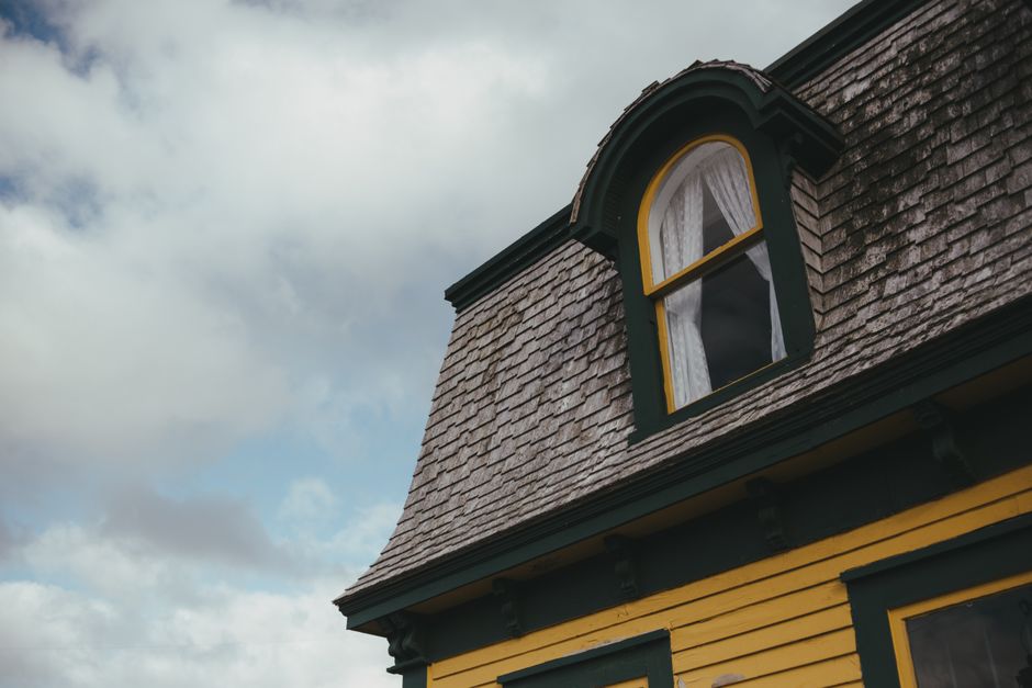 A large Victorian-style house in Guildford with white wooden exterior walls featuring decorative trim and multiple double-hung sash windows. The front entrance has a small porch with columns and a dar